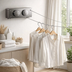 Wall mounted retractable drying rack with shirts hanging in a bright, modern laundry room