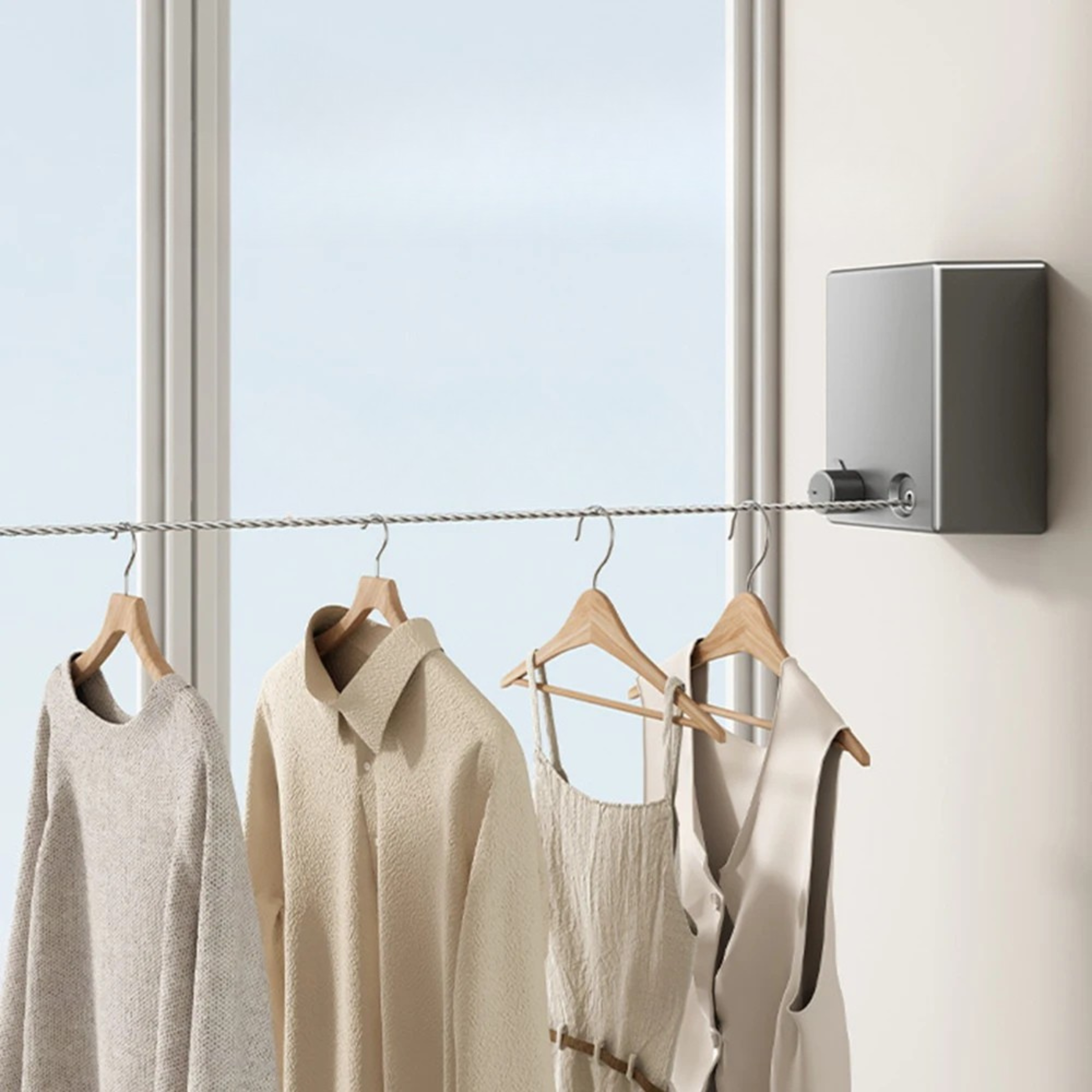 Retractable wall mounted drying rack with clothes hanging in a bright modern room