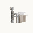 Wall mounted folding towel rack with two towels for bathroom or small space drying.